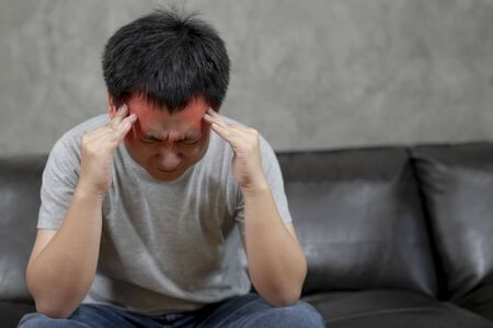 Young man is suffering from a headache,picture showing how much his head hurts,experiencing pain,...