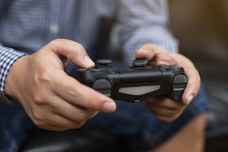 Close up hands of man holding console playing the video game at home.playful enjoyment view concept.