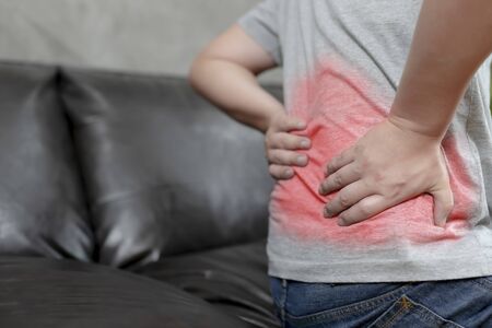 A young man with Low back pain because of hard work, Ache in human body , office syndrome,Bone and...