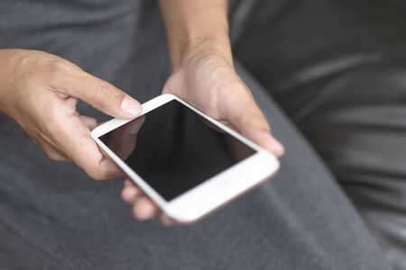 The hand is pressing the phone and remote control to select the channel by application in...