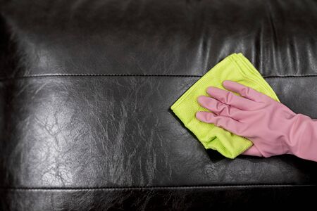 Woman wipe sofa with germicidal spray and wipe with towel.の写真素材