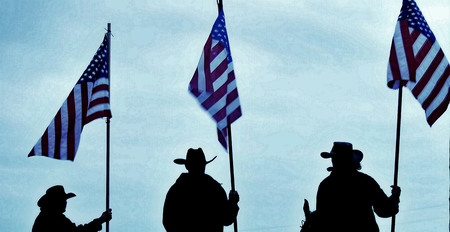 Cowboys Silhouette Carring the Flagsの写真素材