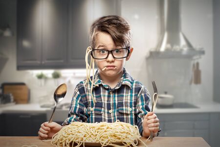 Surprised young boy in glasses with spaghettiの写真素材