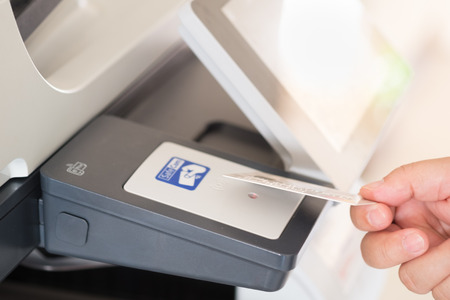 A businessman hand hold card for access Photocopier. Modern induction technology identify personal...