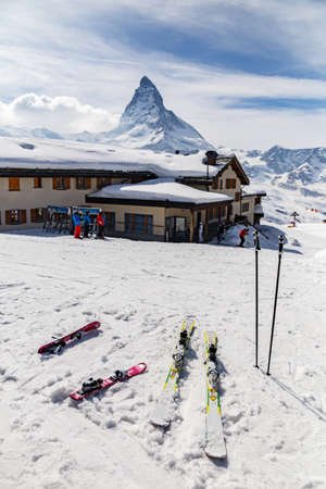 Ski equipment place on snow ground with the background of restaurant and Matterhornの写真素材