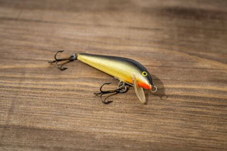 Spoon bait, lure, tackle, flies, wobbler for catching or fishing a predatory fish on deck wood backgroundの写真素材