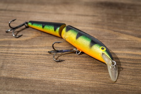 Spoon bait, lure, tackle, flies, wobbler for catching or fishing a predatory fish on deck wood backgroundの写真素材