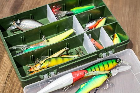 Spoon baits, lures, tackles and wobblers in box for catching or fishing a predatory fish on deck wood backgroundの写真素材