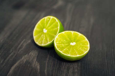 Fresh sliced lime, lemon and salt on wood table.