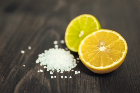 Fresh sliced lime, lemon and salt on wood table.の写真素材