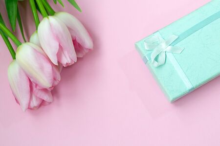 Pink tulips on the pink background with gift box. Flat lay, top view. Valentines background.の写真素材
