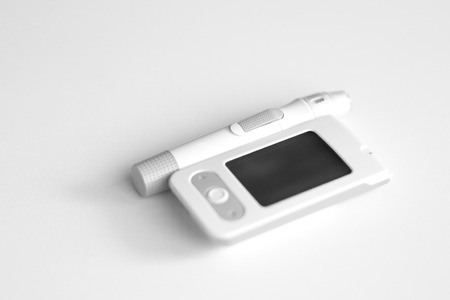 Medicine, diabetes, glycemia, health care and people concept - Glucose meter and lancet device for the diagnosis of glucose.の写真素材
