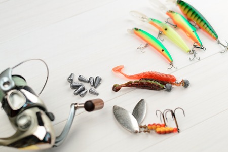 Fishing rod with reel, spoon baits, tackles and wobblers in box for catching or fishing a predatory...