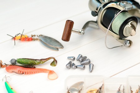 Fishing rod with reel, spoon baits, tackles and wobblers in box for catching or fishing a predatory...