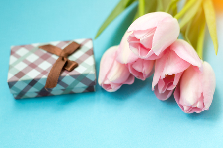 Pink tulips on the blue background with gift box. Flat lay, top view. Valentines background.の写真素材