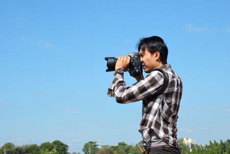 A photographer use his camera to take a pictureの写真素材
