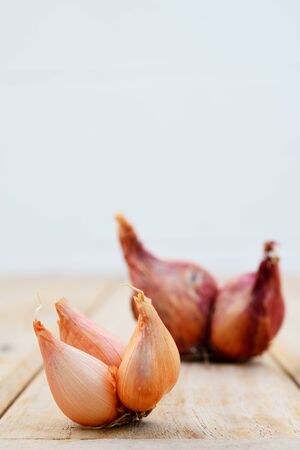 Red onion on the wood floor and white wall の写真素材