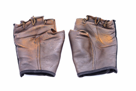 Old leather gloves on isolated white backgroundの写真素材