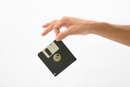 Hand hold black floppy disc on isolated white backgroundの写真素材