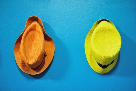 Orange and yellow hat on blue vintage wallの写真素材