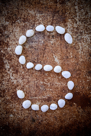 Alphabet made form white stone on rustry floor background.の写真素材