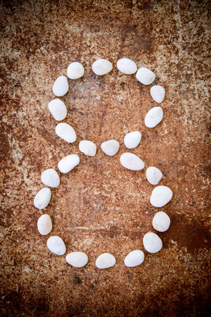 Number alphabet made form white stone on rustry floor background.の写真素材