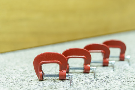 Red C Clamp Row on the rock table with wood backgroundの写真素材