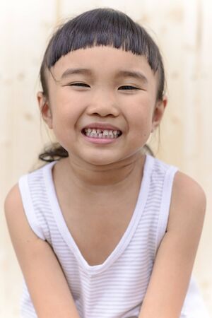 Kid smiling and show her broken tooth with blur backgroundの写真素材