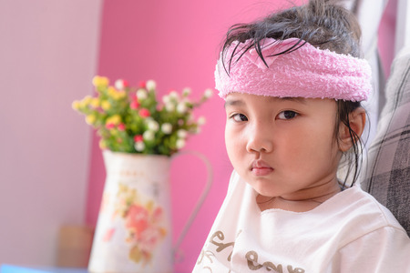 Kid on sick mood with pink towel cold packの写真素材