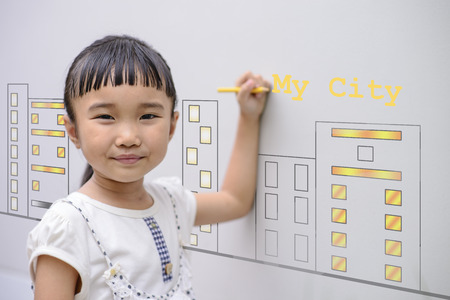 Kid Drawing city design on grey wall backgroundの写真素材
