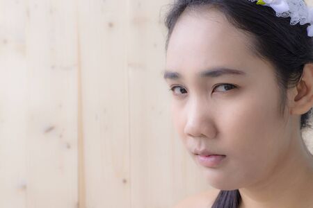 Woman portrait with blur wood wall texture backgroundの写真素材