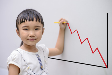 Kid write graph on grey wall with smiling faceの写真素材