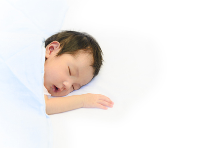Cute baby sleeping on white cotton blanket backgroundの写真素材