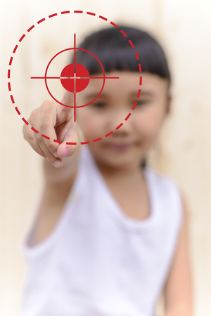 Kid hand push on point and blur face on wood wallの写真素材