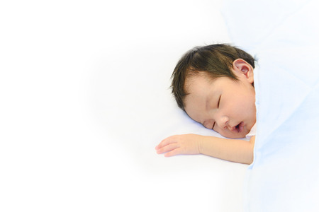 Cute baby sleeping on white cotton blanket backgroundの写真素材