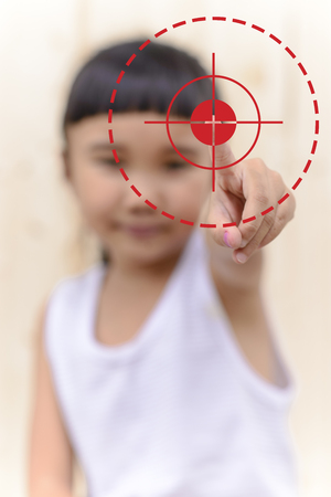 Kid hand push on point and blur face on wood wallの写真素材