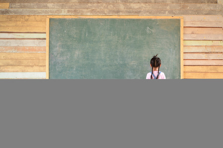 Little girl look at blank green blackboardの写真素材