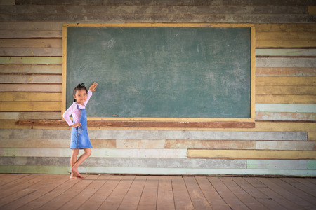 Little girl clear the green chalkboard in the old class roomの写真素材