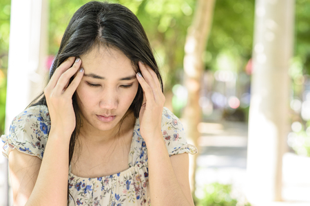 Asian woman on stress pose; serious and worry mood; Headache poseの写真素材