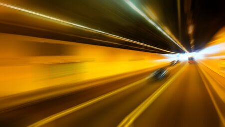 Abstract blurred speed motion in highway road tunnel, moving toward the lightの写真素材