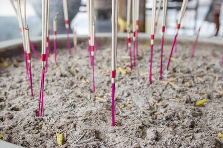 Incense sticks on joss stick pot are burning and smoke use for pay respect to the Buddha.の写真素材