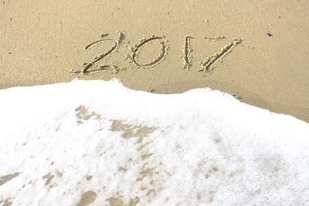 Good bye 2016 hello 2017. inscription written in the beach sand. New Year 2017 is coming concept on the sea beachの写真素材