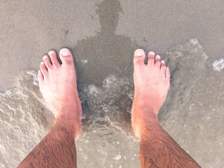 Top View. Close Up of Barefoot Standing on Sandy Beach.
