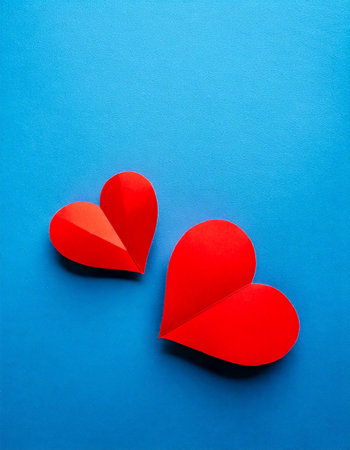 Two red paper hearts on blue background. Valentines day concept.の素材