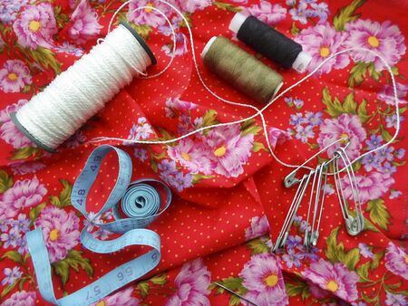 yarn needles pins on red fabric