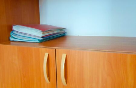 red folders on a wooden shelf