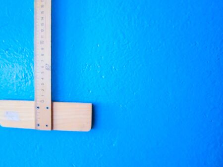 wooden ruler on a blue background. school suppliesの写真素材
