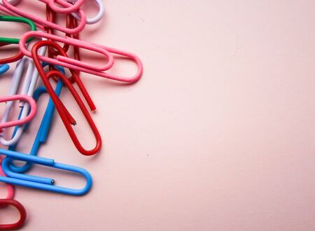 multicolored paperclips on a pink background