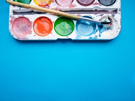 multicolored paints on a blue background
