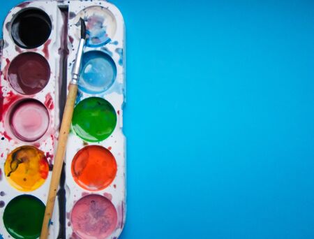 multicolored paints on a blue backgroundの写真素材